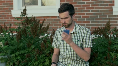 Young Adult Man Talking on Cellphone Outside