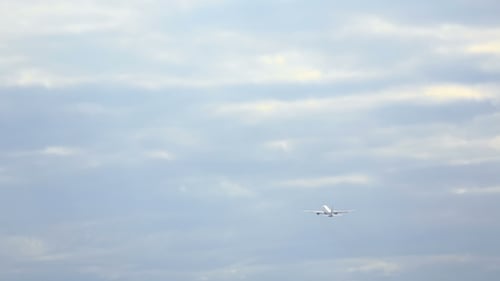 Airplane Flying in a Cloudy Blue Sky