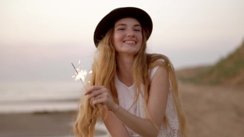 Teenage Beautiful Girl With Sparklers On The Beach At Sunset