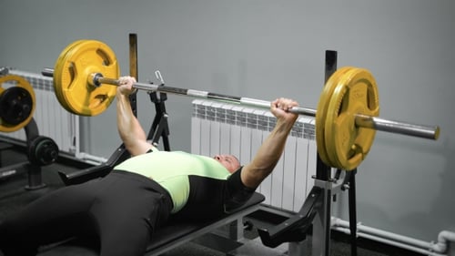 Lying Man Do Exercise With Barbell