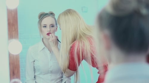 Die Spiegel-Make-up-Arbeit. Maskenbildner malt Lippen