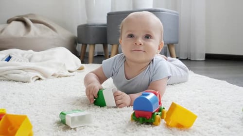 Happy Baby Playing with Toys on Soft Carpet