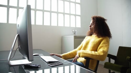 Attractive Black Woman Works On Computer In Office