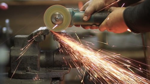 Arbeiter beim Schneiden von Metallwerkstücken mit Kreissäge