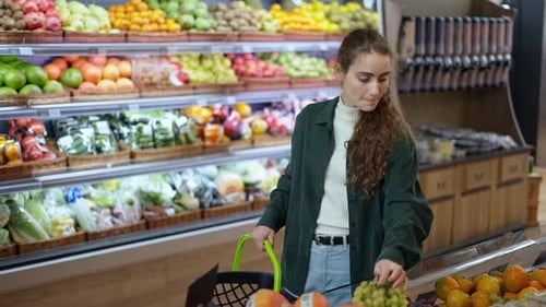Young Woman Shopping for Fresh Grapes in Supermarket