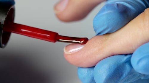 Master Draws The Nails Of Client By a Red Varnish.