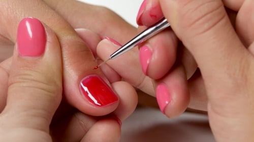 Woman Painting Another's Nails Red, Close Up