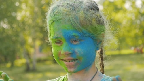 Girl Covered in Colored Powder Smiles at Holi Festival