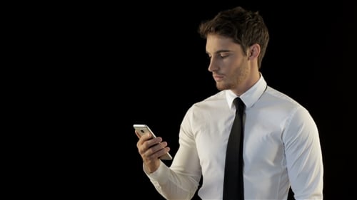 Man Looks At His Smartphone