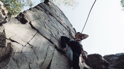 Man Climbing On Cliffed Rock Belay