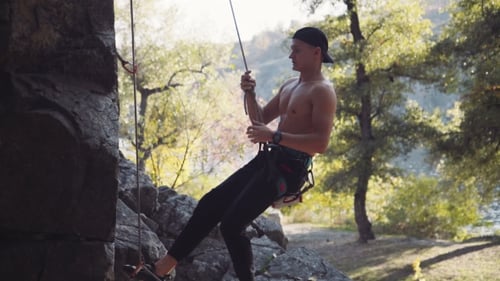 Climber Jumping From Cliff While Hanging On Rope
