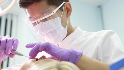 Dentist Cleaning Patient's Teeth in Hospital