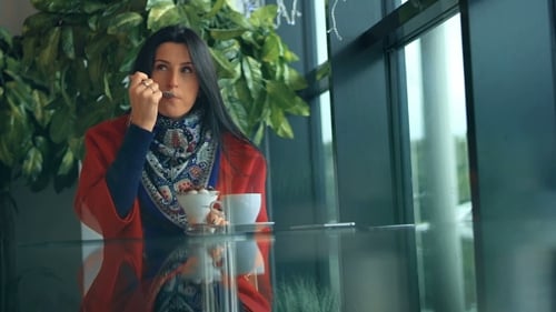 Businesswoman Eating Cake And Drinking Coffee In Cafe