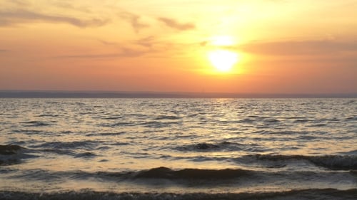 Glänzende Meereswellen am Strand Sand im Sonnenuntergangslicht