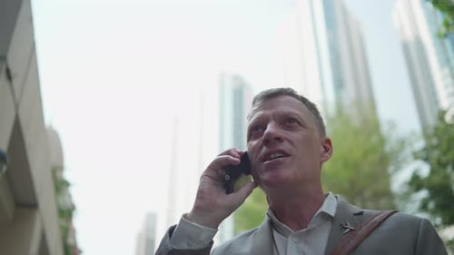 Businessman Talking On Mobile Phone In City Setting