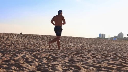 Young Man Jogging on the Beach