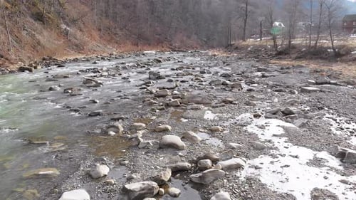 Flying Over Wild Mountain River Flowing with Stone Boulders and Rapids