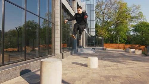 Young Man Parkour Athlete in Urban Modern City Doing Extreme Tricks Slow Motion