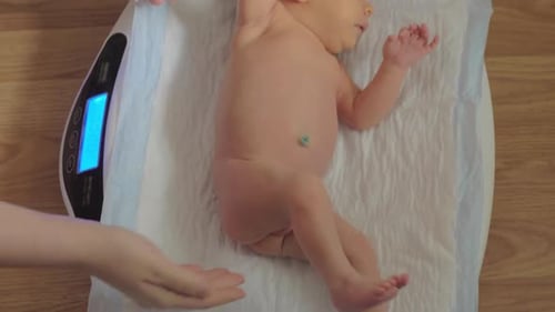 Infant Placed on Scale by Parent Indoors