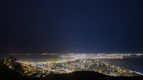 Time lapse 4K - Noite com estrelas e neblina na cidade.