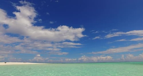 Wide flying island view of a white sand paradise beach and turquoise sea background in colourful 4K