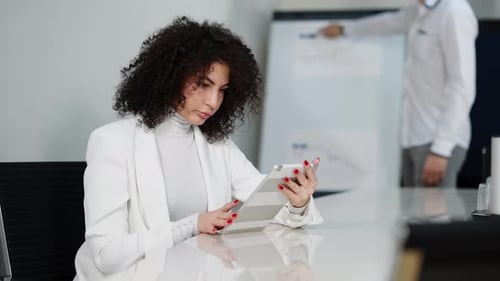 Woman Works on Tablet in Modern Office