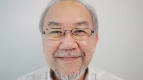 Close Up Portrait of Smiling Senior Man with Glasses