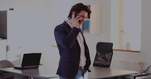 Businessman Discussing on Smart Phone in Office