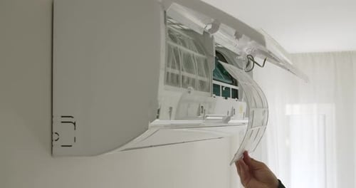 Hand Installing Air Conditioner Filter Indoors