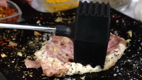 Cook Beats Frisches rohes Schweinefilet mit Fleischhammer auf Küchenbrett Kochkoteletts