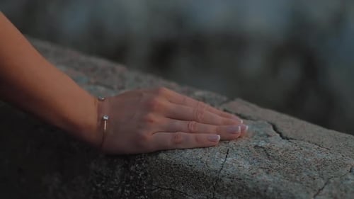 Woman hand with jewelry on the rock, put bracelet on wrist