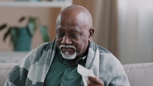 Unhealthy Mature Elderly Grandpa Wiping Nose Blowing Snot in Paper Napkin Sick African American Man