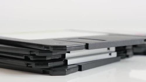 Lot of diskette data archives stacked 4K 2160p 30fps UHD tilting footage - Black floppy disc class