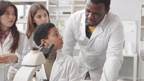 Female Student Using Microscope at Science Class