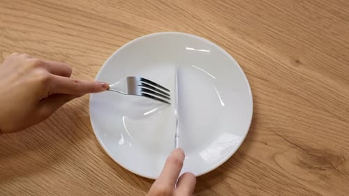Silverware Placed on White Plate on Wooden Table