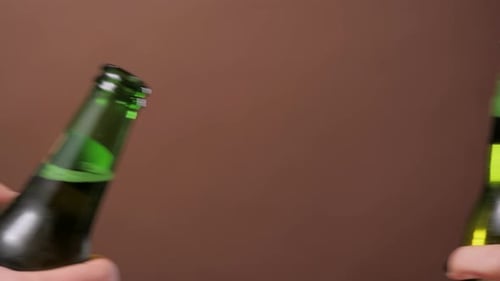 Gros plan des mains grillant avec des bouteilles de bière