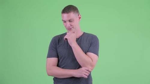 Young Adult Male Thinking in Front of Green Screen