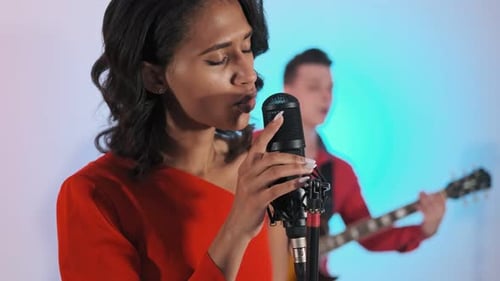 Musicians of Rock Band in Studio Playing Songs with Lights on Background