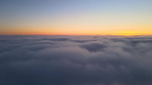 Aerial View From Above at High Altitude of Dense Puffy Cumulus Clouds Flying in Evening