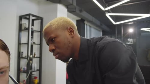 Barber Cuts Man's Hair in a Stylish Shop