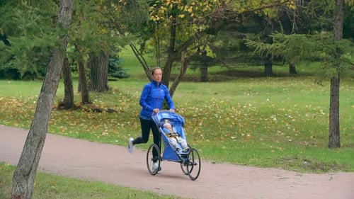 Woman Jogging with Child in Stroller in Park