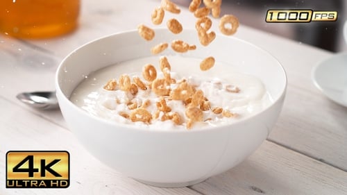 Circle-Shaped Cereals Falling into Bowl with Milk