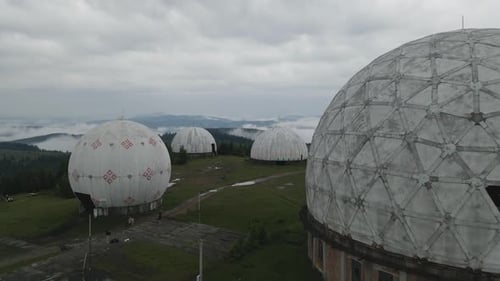 Toma aérea volando rápidamente a través y sobre una estación de radar soviética abandonada en Ucrania. Monte de los Cárpatos