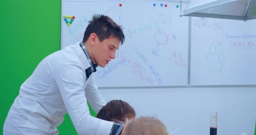 Teacher Explaining an Experiment to a High School Chemistry Class Together