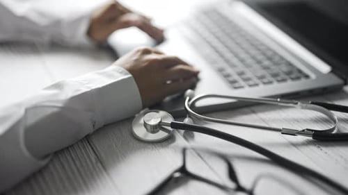Close Up of a Doctor is Working and Typing on Laptop in a Clinic