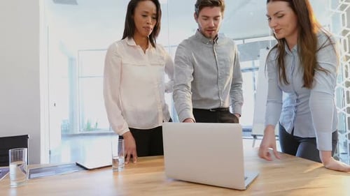 Team Collaborating on Laptop in Modern Office