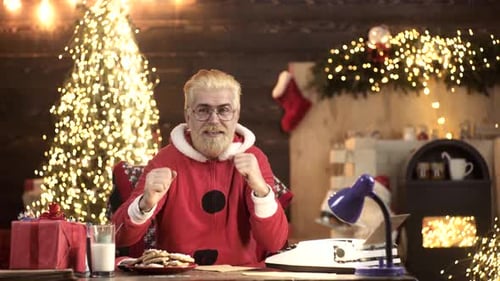 Man Dances in Santa Suit by Christmas Tree