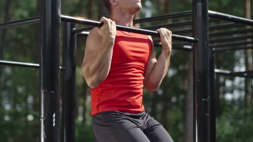 Muscular Man Doing Pull-Ups in Outdoor Gym
