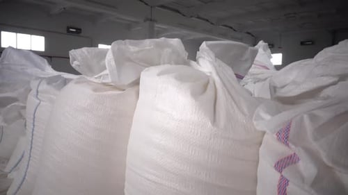 White Sacks with Flour Sugar Groats or Pasta in a Production Warehouse