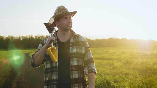 Rural Farmer Walking with Hoe in Sunlit Field
